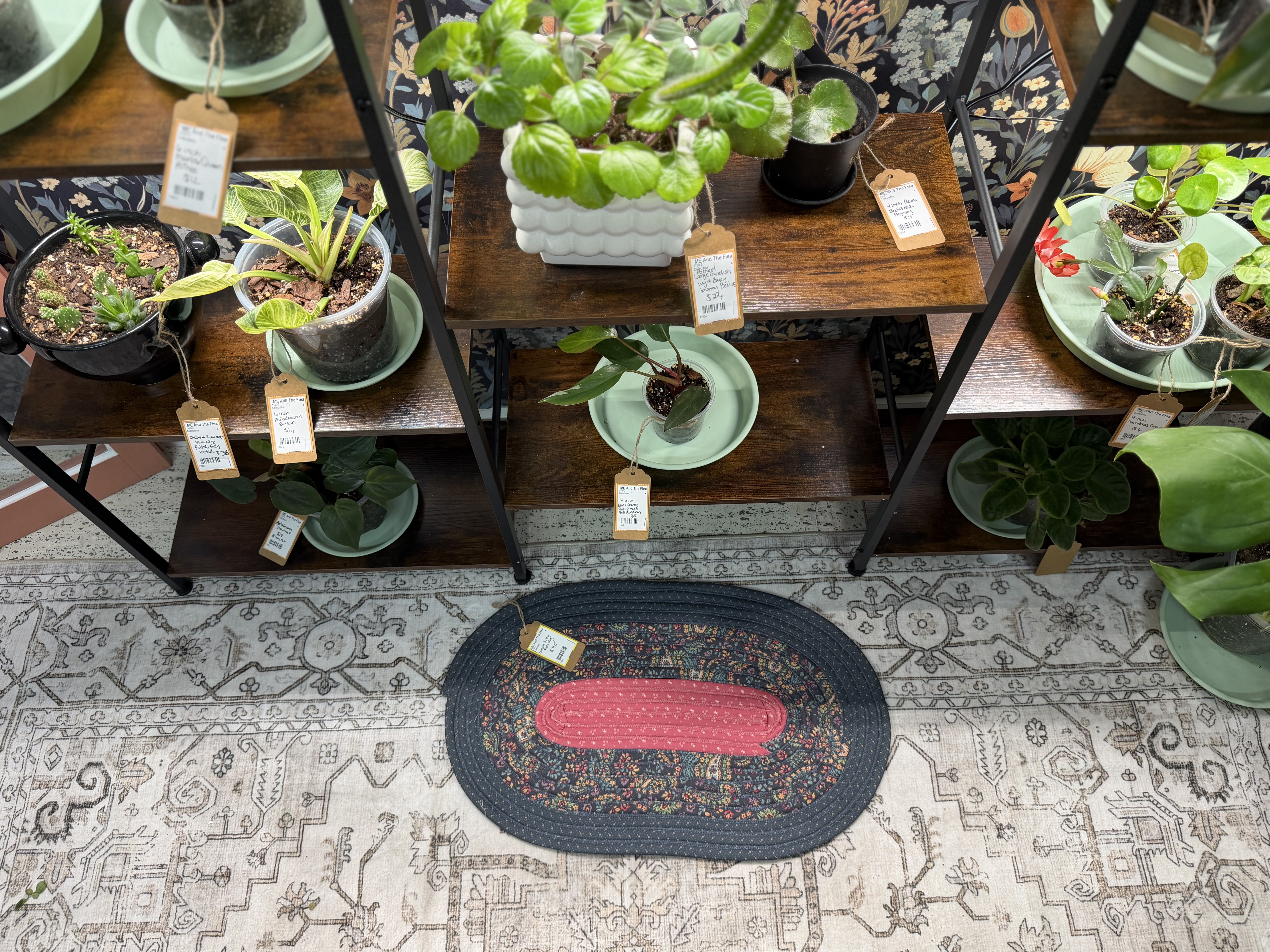 Kristi Rosenow's dark oval braided rug with a rose-colored center on the Rooted Craft Co booth floor